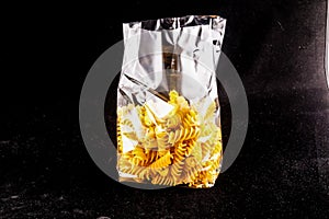 A bag of pasta is sitting on a black surface