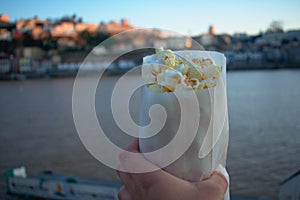 Bag of popcorn in hand along the Duoro river in Porto Portugal