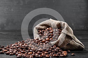 Bag with scattered coffee beans isolated on the black background