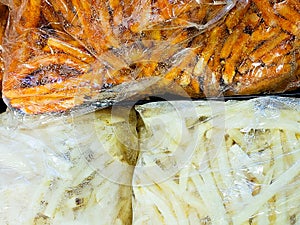 A bag of sweet potato fries and white potato fries side by side