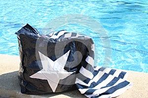 Bag and towel beside Swimming Pool