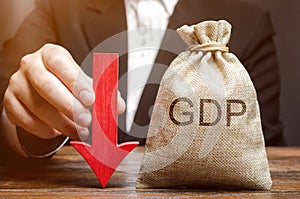 A bag with the word GDP and a down arrow in the hands of a businessman. Decline and decrease of GDP - failure and breakdown of