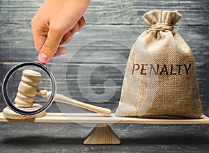 Bag with the word Penalty and gavel on the scales. Penalty as a punishment for a crime and offense. Fraud. The court`s decision. photo