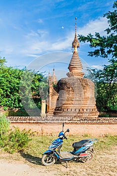 BAGAN, MYANMAR - DECEMBER 9, 2016: E-bike (electric scooter) in front of a stupa in Bagan, Myanm