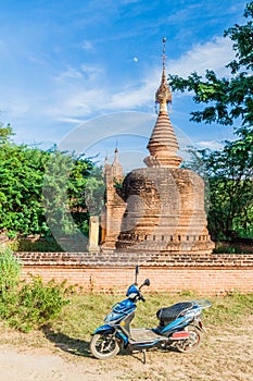 BAGAN, MYANMAR - DECEMBER 9, 2016: E-bike (electric scooter) in front of a stupa in Bagan, Myanm photo