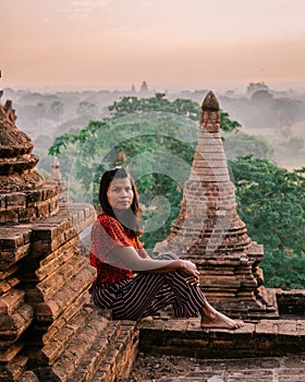 Bagan Myanmar, young woman watching Sunrise by an Budism temple pagoda at the historical site of Pagan photo