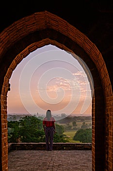 Bagan Myanmar, young woman watching Sunrise by an Budism temple pagoda at the historical site of Pagan photo