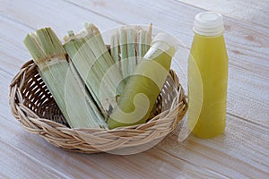 Bagasse after squeezing for a drink in basket and bottles of fresh sugar cane juice.