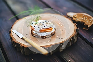 bagel with cream cheese and almond slivers on rustic wood