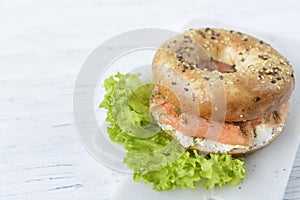 Bagel with cream cheese, salmon slices, dill and salad