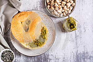 Bagel with pistachio cream butter for breakfast on a plate on the table top view