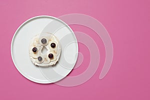 Bagel on a plate on a pink background