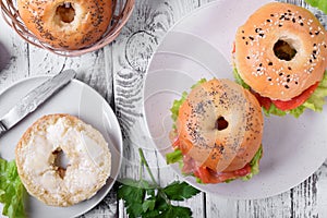 Bagel sandwich with smoked salmon and lettuce salad on ceramic plate