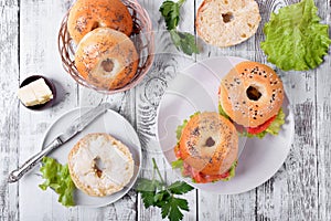 Bagel sandwich with smoked salmon and lettuce salad on ceramic plate