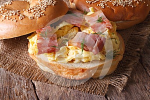 Bagel with scrambled eggs and bacon close-up horizontal