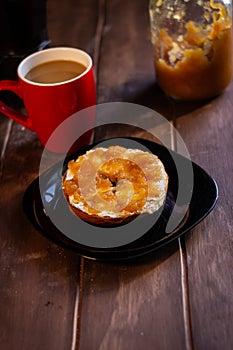 Bagel sponge cake breakfast with apple jam and coffee in red cup and Italian coffee pot on wooden table