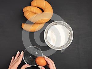 Bagels, flour, egg on a black background