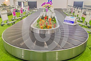 Baggage conveyer with beautiful orchid decoration at Mae Fah Luang - Chiang Rai International Airport, Chiang Rai, Thailand