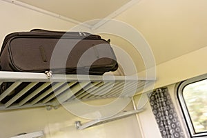 Baggage sitting on train rack in compartment