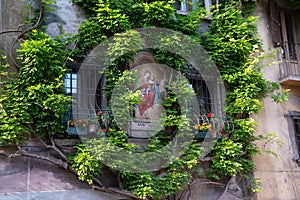 Bagolino medieval village, green wall with religious frescoes.