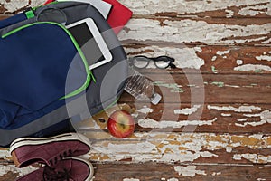 Bagpack, water bottle, apple, digital tablet, shoes and spectacle photo