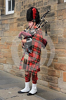 The street bagpiper in the city Edinburgh in Scotland.