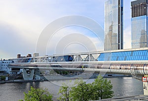 The Bagranion pedestrian bridge across the Moscow River against the background of high-rise buildings under construction