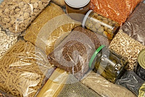 Bags of cereals and pasta, jars of marinades of vegetables, grains of cereals, porridge. Humanitarian aid with food, a grocery set