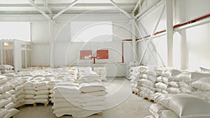 Bags with flour in warehouse of flour factory. Flour stock. Mill warehouse