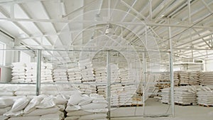 Bags with flour in warehouse of flour factory. Flour stock. Mill warehouse