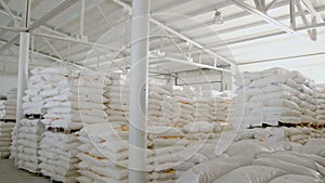 Bags with flour in warehouse of flour factory. Flour stock. Mill warehouse