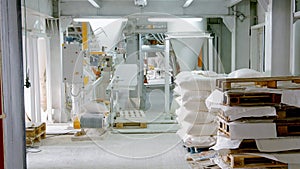 Bags with flour in warehouse of flour factory. Flour stock. Mill warehouse