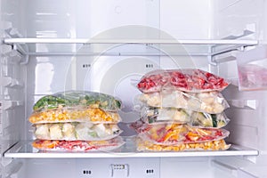 Bags with frozen vegetables in refrigerator