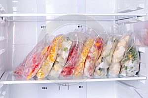 Bags with frozen vegetables in refrigerator