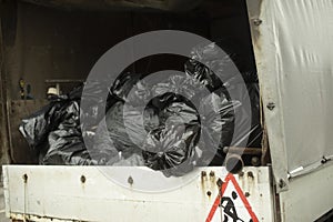 Bags of garbage in car. Black packages in back of car