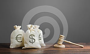 Bags of money and a judge`s hammer. Litigation on financial matters. Legislation and rules, laws in the finance sector of economy