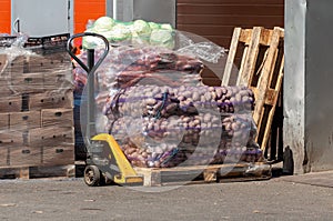 Bags of potatoes are stacked on a hand pallet truck