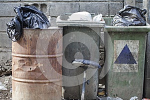 Bags Surrounding Overflowing Waste Collection Bins Outdoors.Old