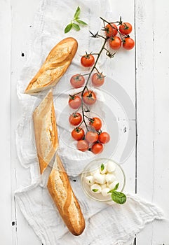 Baguette with banch of cherry-tomatoes, basil and