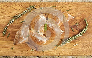 Baguette on a counter next to a cutting board with a knife and seasonings