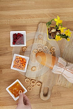 Baguette on a cutting board and three bowls of jam