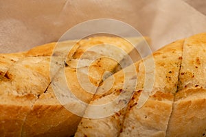 Baguette with garlic paste cut into pieces, close-up, selective focus