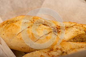 Baguette with garlic paste cut into pieces, close-up, selective focus