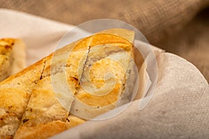 Baguette with garlic paste cut into pieces, close-up, selective focus