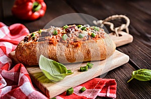 Baguette stuffed with minced meat, tomato sauce, bell pepper, beans, onion, garlic and cheese