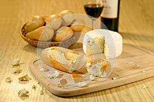 Baguettes in a basket, cheese and wine