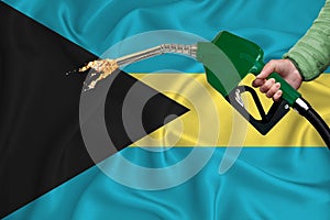 BAHAMAS flag Close-up shot on waving background texture with Fuel pump nozzle in hand. The concept of design solutions. 3d