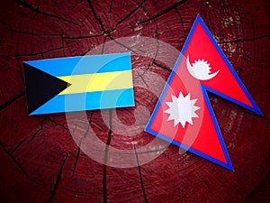 Bahamian flag with Nepali flag on a tree stump isolated