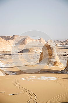 Bahariya landscape with lime stone rock formations. Desert nature. Car tracks towards the valley. Wilderness exploring.