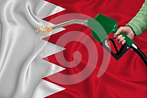 BAHRAIN flag Close-up shot on waving background texture with Fuel pump nozzle in hand. The concept of design solutions. 3d